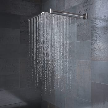 Modern shower head is spraying water in a grey tiled bathroom