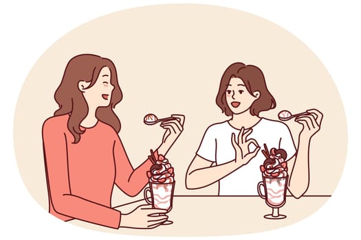 Women having lunch sitting in restaurant eating milkshake and discussing personal lives or plans for weekend. Girlfriends eat ice cream or milkshake in cafe wanting to cool off in hot summer weather