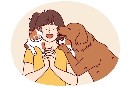 Little girl with pets enjoys communicating with cat sitting on shoulder and dog licking face. Teenage girl laughs rejoicing at presence of pets and makes friends with kitten and puppy