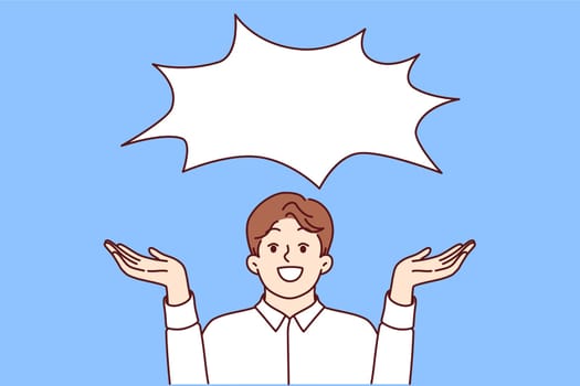 Happy business man offering good idea or communicating profitable offer, standing under empty dialogue cloud. Laughing businessman happily spreads arms to sides, showing copy space for your idea