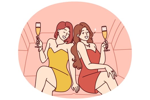 Celebrity women sit in luxury car with glasses filled with sparkling wine during pre-wedding bachelorette party. Celebrity girls in evening dresses riding in limousine enjoy premium atmosphere