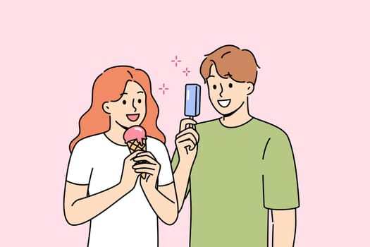 Man and woman eat ice cream to refresh themselves and satisfy hunger during summer walk. Delicious fruit ice cream on stick or in waffle cup in hands of happy teenagers walking around city