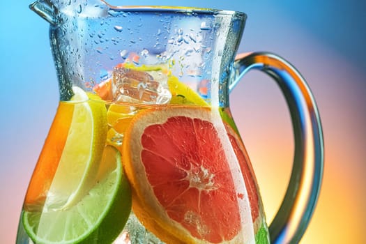 Close-up of a refreshing fruit-infused water pitcher with ice cubes and slices of citrus fruits.
