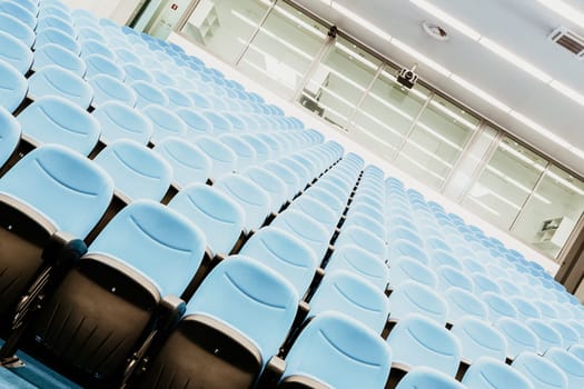 Interior of empty conference hall with blue velvet chairs.