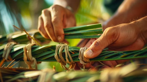 Close-up of hands connecting long stems into a rope, with a blurred background in the background.lost crafts