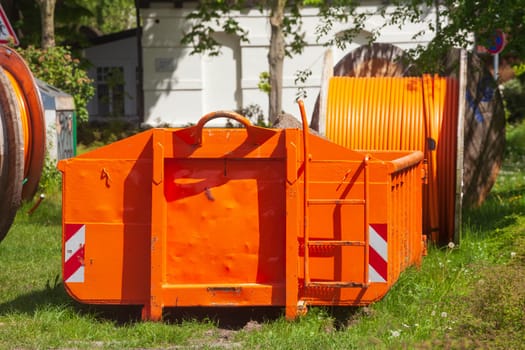 Container, orange skip for building rubble standing on a meadow, Germany