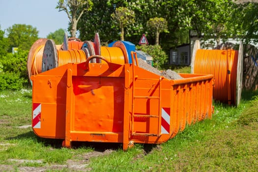 Container, orange skip for building rubble standing on a meadow, Germany