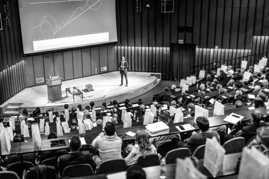 Speaker Giving a Talk at Business Meeting. Audience in the conference hall. Business and Entrepreneurship concept. Black and white image.