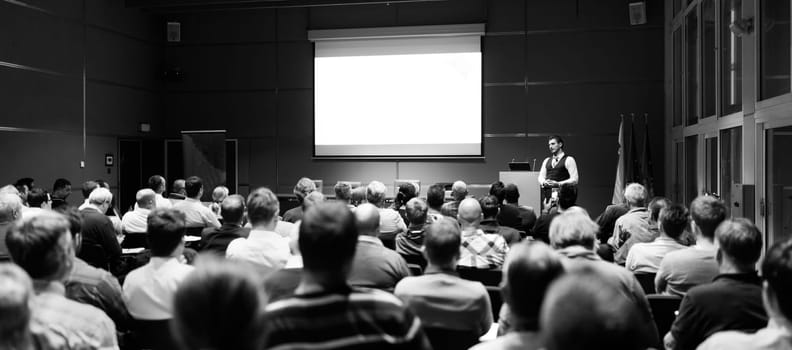 Speaker Giving a Talk at Business Meeting. Audience in the conference hall. Business and Entrepreneurship concept. Black and white.