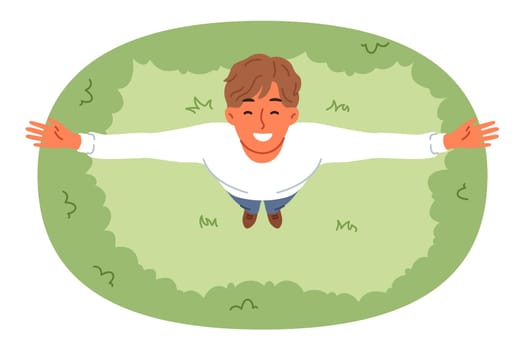 Happy man stands on lawn and looks up enjoying rays of sun and fresh air on summer day. Guy smiles and puts hands to side, feeling freedom and surge of positive emotions due to summer holidays