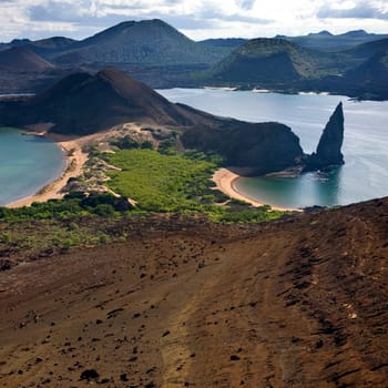 Pinnacle Rock and Volcanic landscape of cinder cones and lava fields on the island of Bartolome in the Galapagos Islands - Ecuador