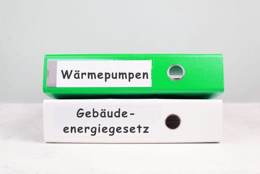 Heat pumps, new building energy act stands in german language on the folders, climate protection policy to reduce co2 emission