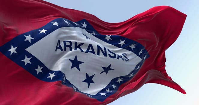 Arkansas state flag waving in the wind on a clear day. Red field with blue-bordered white diamond. 29 stars and ARKANSAS in blue. 3d illustration render. Selective focus. Fluttering fabric.