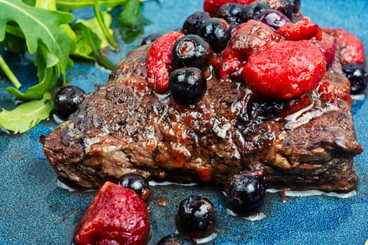 Fried beef fillet medallion steak with berry sauce on the table. Healthy food.