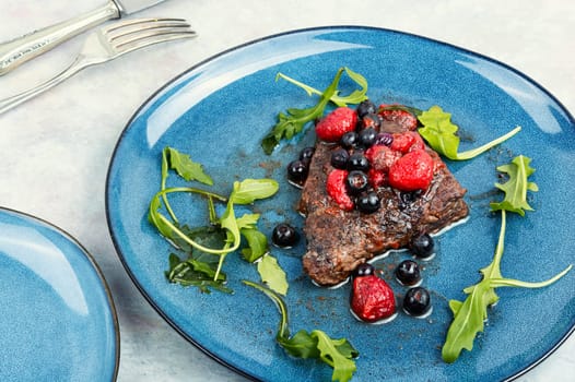Fried beef fillet medallion steak with berry sauce on the table. Healthy food.