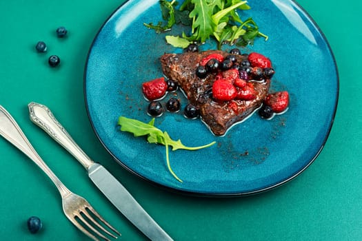 Fried beef fillet medallion steak with berry sauce on the table. Healthy food.