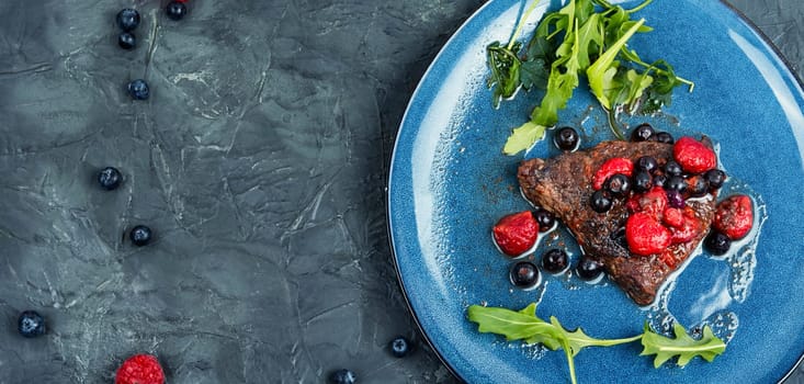 Fried beef fillet medallion steak with berry sauce on the table. Healthy food.