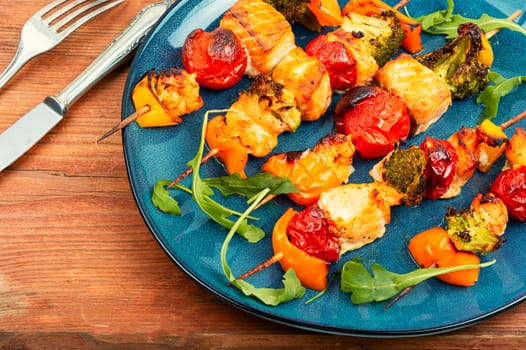 Skewers of fish salmon and vegetables on wooden stick. Seafood kebab. Copy space. Long banner.