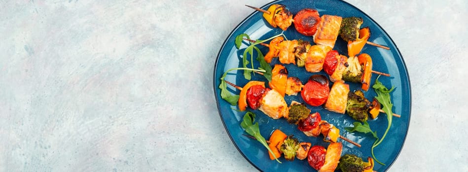 Skewers of fish salmon and vegetables on wooden stick. Seafood kebab. Copy space. Long banner.
