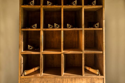 Roman shelf with various papyrus scrolls. Ancient furniture