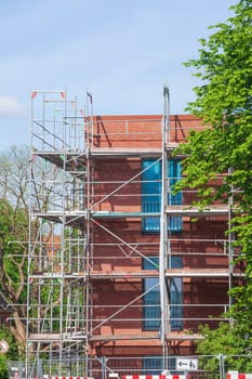 Scaffolding on the shell of a red brick residential building, Germany