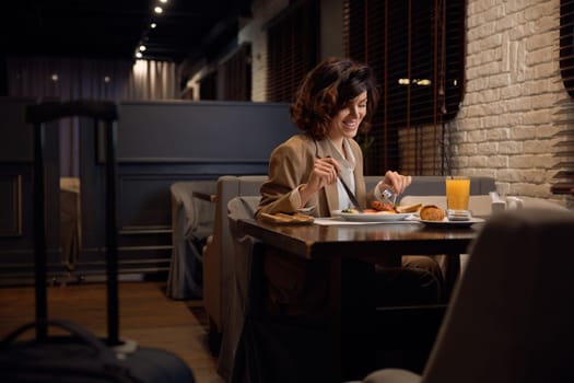 Pretty businesswoman eating lunch at hotel restaurant. Break time during business trip