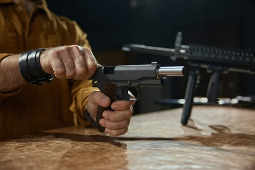 Weapon store and firearm exhibition advertisement. Male retailer or client reloading handgun portrait with selective focus
