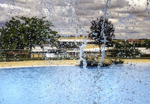 Detail of waterfall in a swimming pool in summer, vacation