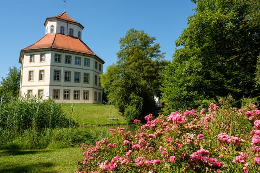 City hall building in former castle with blooming roses in garden