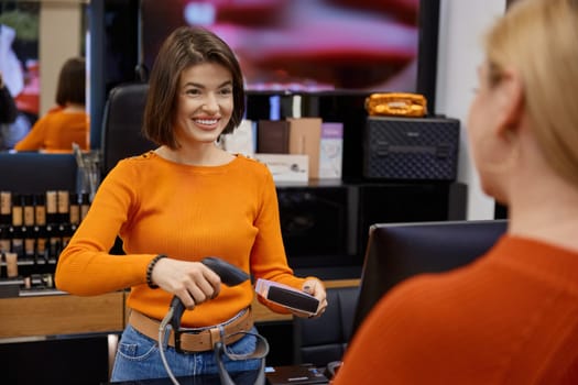 Attractive positive lady working in cosmetics store making a purchase. Smiling saleswoman in shop with stuff for face