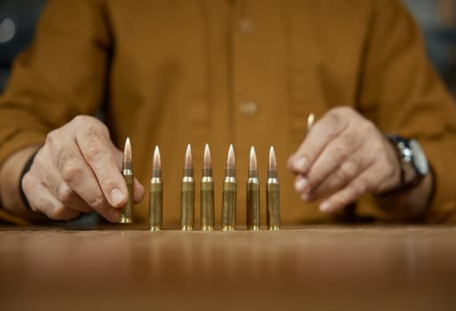 Salesman puts out firearm cartridges for customer on counter desk closeup. Weapon shop with military ammunition for army and special forces