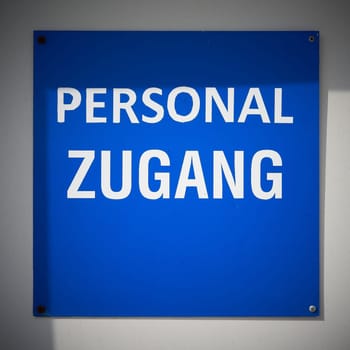 Sign with the German inscription Personalzugang on the entrance door to a store in Cologne. Translation: Staff entrance