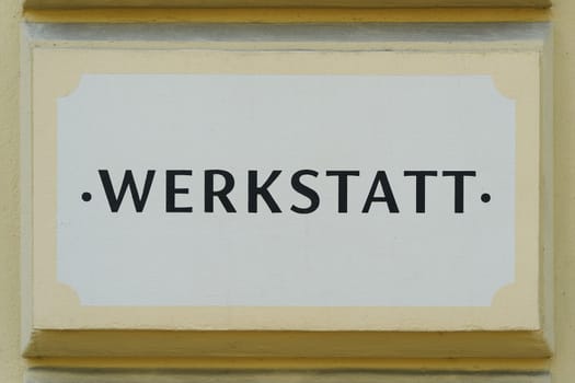 German inscription Werkstatt on the facade of a craft business in Berlin. Translation: Workshop