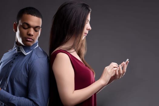 suspicious man glances at a womans phone use, fearing her sexual unfaithfulness despite exclusive commitments, revealing deep trust issues and personal insecurities in their relationship
