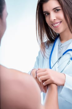 Doctor is holding the hand of her patient, smiling reassuringly, offering support and empathy during a difficult time