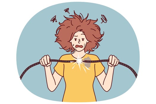Woman with damaged electrical wire suffers from electric shock and power failure. Funny girl with disheveled hair was shocked after feeling shock from electricity and trying to fix wiring