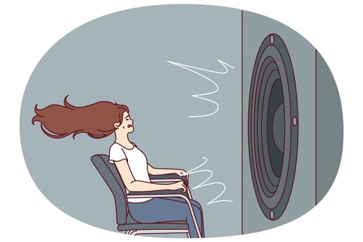 Deafened woman near giant subwoofer from music center listening to loud rhythmic track with bass sitting in chair. Subwoofer with round speaker produces loud sound waves for girl who loves rock songs