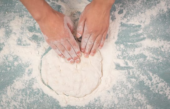 Baker kneading dough for pizza or artisan bread with his hands, prepare ingredients for food, baking pastry