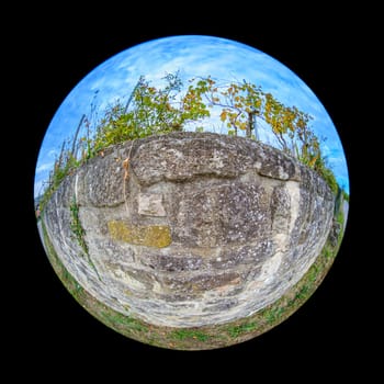 Huge stone wall with vines in a vineyard landscape scene in fish-eye distortion