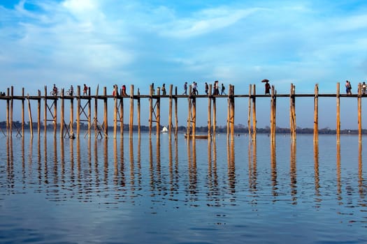 U Bein Bridge at sunset. Amarapura near Mandalay in Myanmar (Burma). The footbridge, over Taungthaman Lake, was constructed in 1849 using reclaimed teak columns by the then mayor of Amarapura, U Bein. It is 1.2Km long.