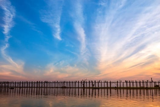 U Bein Bridge at sunset. Amarapura near Mandalay in Myanmar (Burma). The footbridge, over Taungthaman Lake, was constructed in 1849 using reclaimed teak columns by the then mayor of Amarapura, U Bein. It is 1.2Km long.