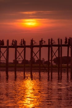 U Bein Bridge at sunset. Amarapura near Mandalay in Myanmar (Burma). The footbridge, over Taungthaman Lake, was constructed in 1849 using reclaimed teak columns by the then mayor of Amarapura, U Bein. It is 1.2Km long.