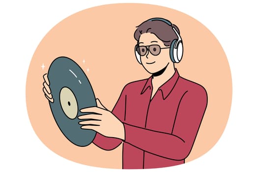 Hipster man with vinyl record listens to music in headphones, collecting retro discs with audio recordings. Guy looks at vinyl record and rejoices in buying rare copy with recording of concert