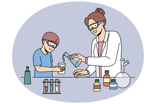Woman teacher of chemistry teaches boy to conduct laboratory experiments and mix reagents in test tubes. School laboratory with flasks filled with chemical liquids for teaching children