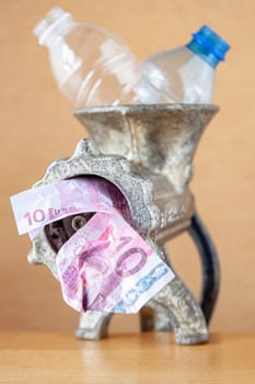 Plastic bottles in a meat grinder for recycling. Selective focus with shallow depth of field.