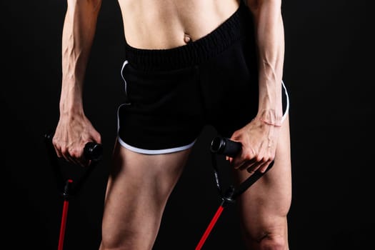 Athletic female performs exercises using resistance band. Strength and motivation