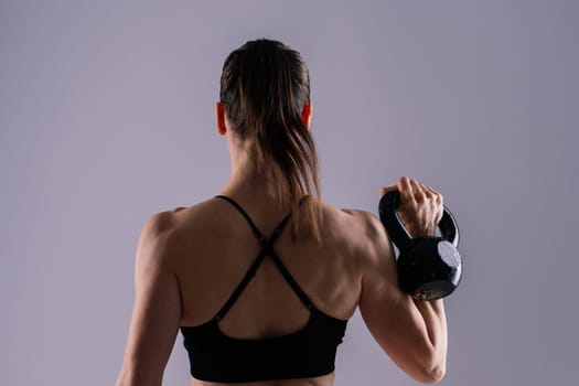 Slim, woman and kettlebell in workout for fitness, exercise and wellness with weight in a studio.