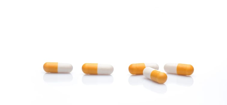 Yellow and white capsule pills on white background. Prescription drugs. Healthcare and medicine. Pharmaceutical industry. Pharmacy product. Vitamins and dietary supplements. Medical and health care.