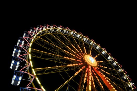 Large colorfully illuminated Ferris wheel at dark night