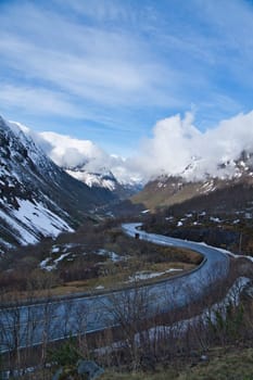 Norwegian landscape. The road leads through a mountain gorge that descends from the glacier. Rough nature in Scandinavia. Landscape photo from the north